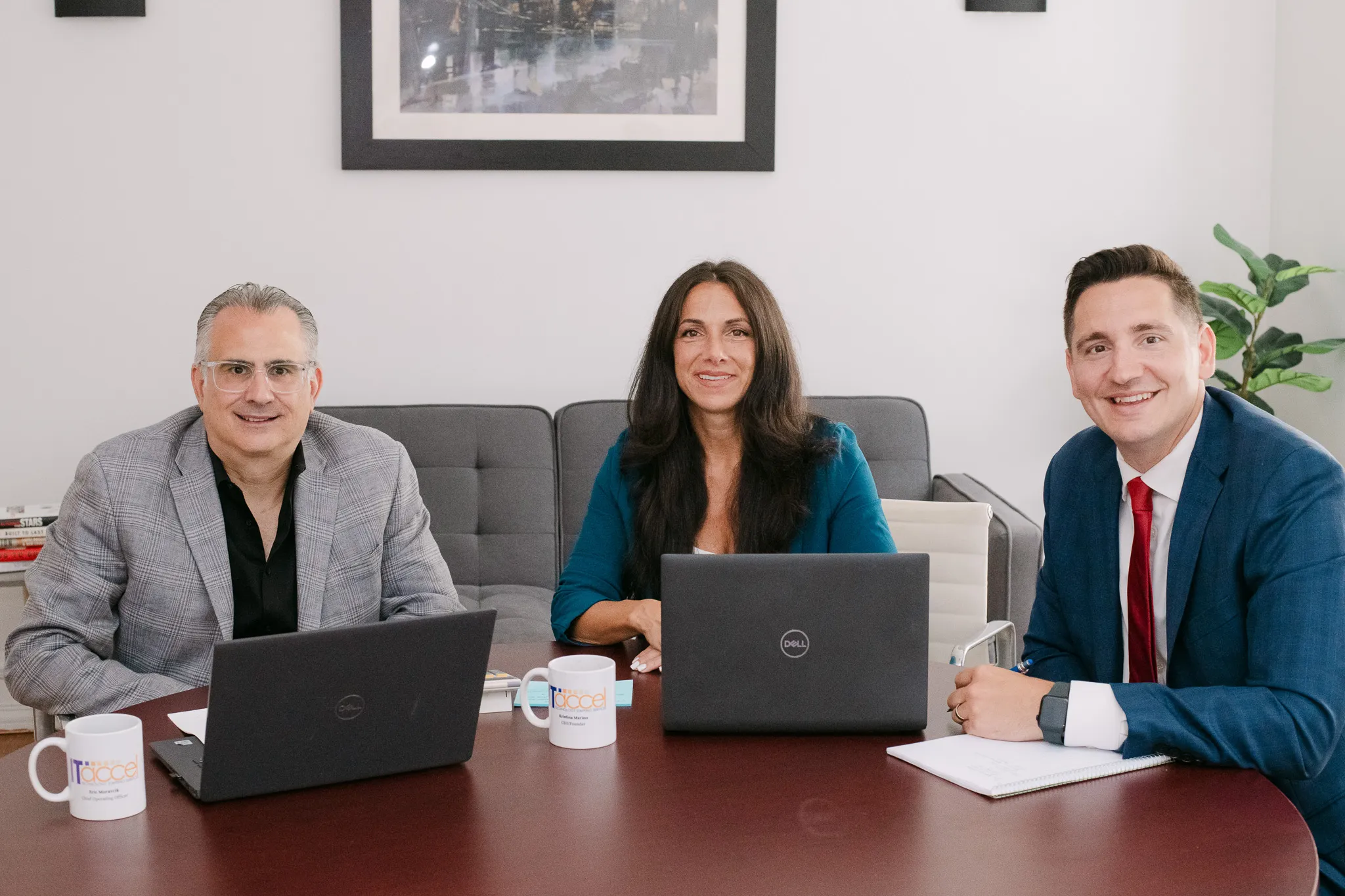 ITAccel leadership team meeting around a conference table with laptops, discussing executive recruiting and technology staffing solutions.”
